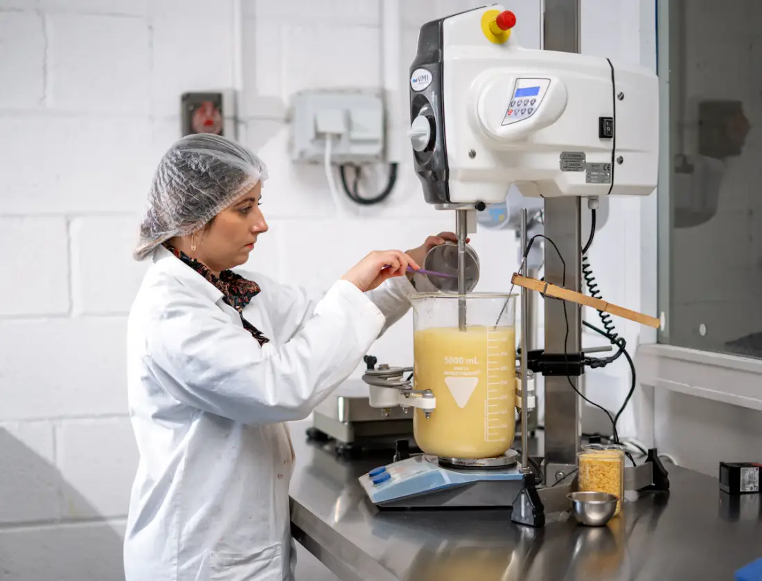 A quality specialist preparing a herbal formulation in a clean facility